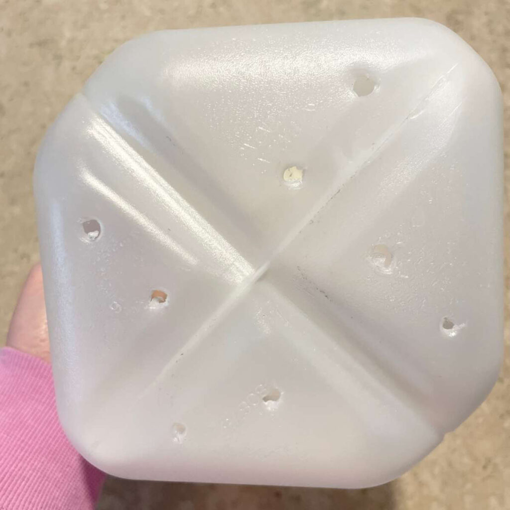 holes poked into bottom of milk jug